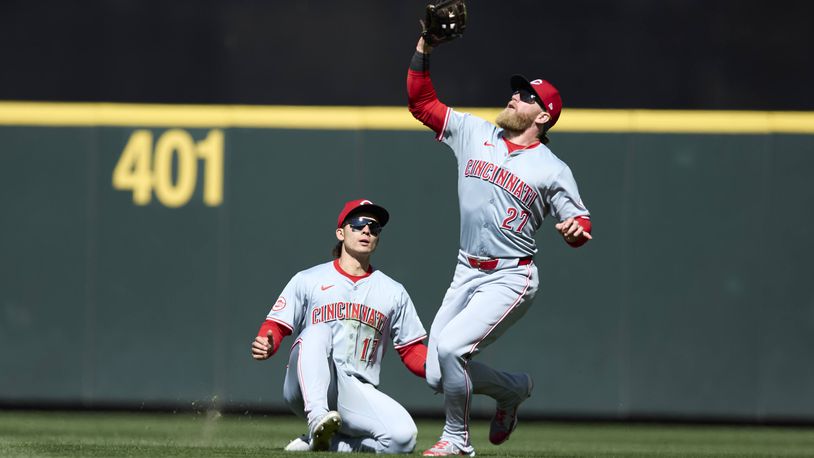 Cincinnati Reds right fielder Jake Fraley reaches and catches a fly ball with center fielder Stuart Fairchild sliding behind for an out hit by Seattle Mariners' Jorge Polanco during the seventh inning of a baseball game, Wednesday, April 17, 2024, in Seattle. The Mariners won 5-1. (AP Photo/John Froschauer)