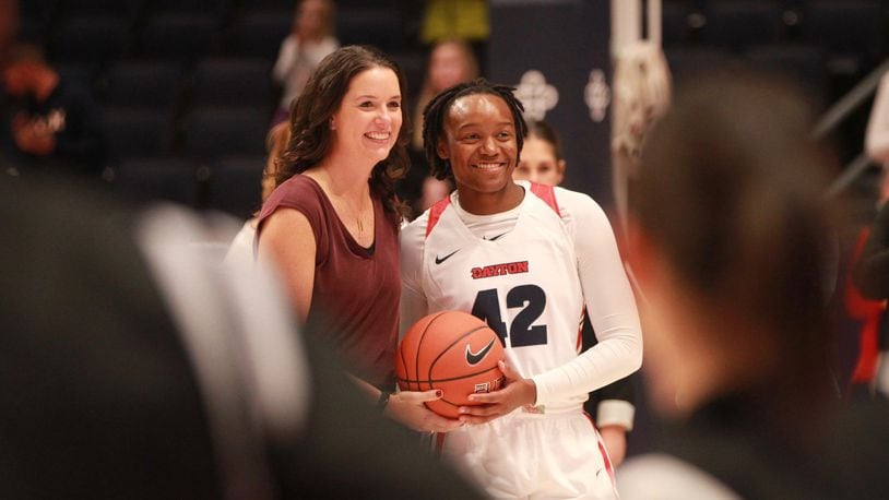 Dayton’s Shauna Green presents Jayla Scaife with a basketball in honor of her 1,000th career point, scored late last season, before a game against Lipscomb on Tuesday, Nov. 5, 2019, at UD Arena. David Jablonski/Staff