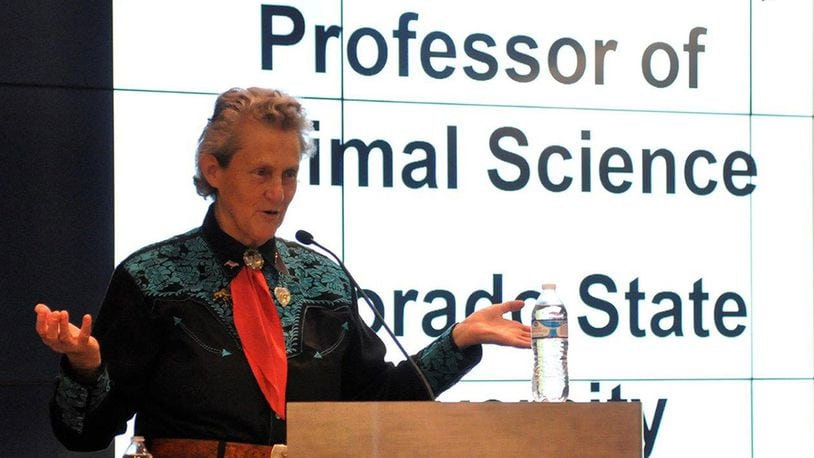 Dr. Temple Grandin greets the audience at her lecture for the Diversity Speakers Series June 28 at the Air Force Institute of Technology, sponsored by the Air Force Research Laboratory. Grandin is an acclaimed livestock industry consultant, professor of animal science at Colorado State University and autism spokesperson. (U.S. Air Force photo/Caroline Clauson)