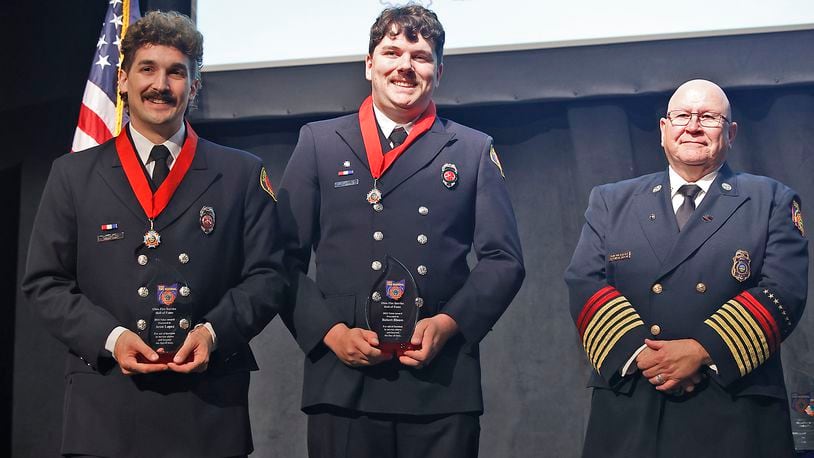 Springfield firefighters Robert Bloom, right, and Aaron Lopez pose for a picture with State Fire Marshal Kevin Reardon during the 43rd Annual Ohio Fire Service Hall of Fame and Fire Awards Wednesday, April 24, 2024 in Columbus. Bloom and Lopez received the Fire Service Valor Award for saving a baby from a townhouse that exploded last year. BILL LACKEY/STAFF