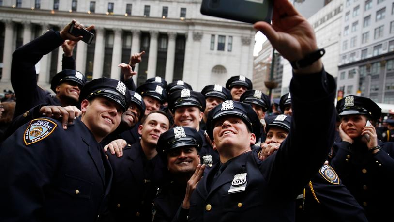 New NYPD Police Academy graduate Frank Cinturati, front, takes a selfie with his company after their graduation ceremony at Madison Square Garden in New York, Wednesday, Dec. 28, 2016. The ceremony celebrated 555 new officers who just completed their 6 months training. (AP Photo/Seth Wenig)