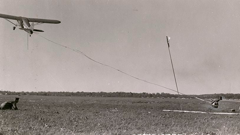 This photograph was taken in 1943 in the midst of the Second World War. The caption on the back of the photograph claims that Wright-Patterson was the site of the first pickup by a flying aircraft of a man on the ground. Presumably the experiment was undertaken to find ways of extracting downed airmen on the ground. The aircraft being used in this experiment is a UC-47 Norseman, a Canadian built aircraft used by the US Army Air Forces as a utility aircraft. DAYTON DAILY NEWS ARCHIVES