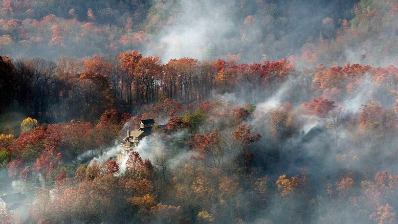 Smoke surrounds a home as seen from aboard a National Guard helicopter near Gatlinburg, Tenn. (AP Photo/Erik Schelzig)