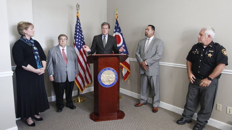 U.S. Rep. Mike Turner (center), R-Dayton, and Montgomery County Sheriff Phil Plummer (right) have sent a letter asking leaders of the Dayton Area Chamber of Commerce and Dayton Development Coalition to help select a Dayton regional drug czar to coordinate a response to the opioid crisis. They announced the effort Sept. 25. The others from left are Fairborn Municipal Court Judge Beth Cappelli, Greene County Commissioner Bob Glaser and Dr. Jean Wright, who is involved in combating the crisis in Philadelphia. CHRIS STEWART / STAFF