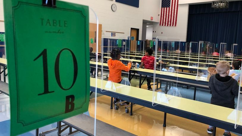 Students eat lunch at Dayton's River's Edge Montessori School during November, sitting far apart, with plexiglass dividers between them. CONTRIBUTED PHOTO