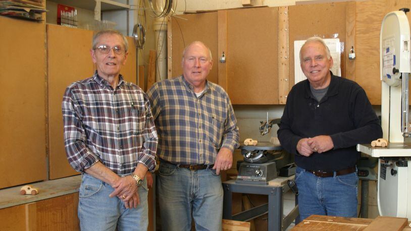 Ron Agnor (from left), Terry Holdcraft and Ron Marks volunteer in the large wood shop at St. Leonard in Centerville crafting tiny wooden cars for children all over the world. (Not pictured: Bob Cooper.) PAMELA DILLON/CONTRIBUTED