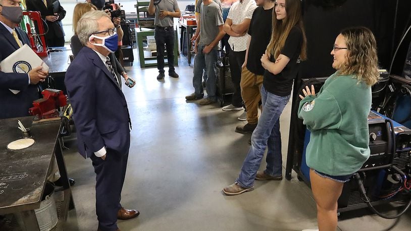Governor Mike DeWine talks with Clark State College students in the school's Welding Lab Monday as he tours the facility. BILL LACKEY/STAFF