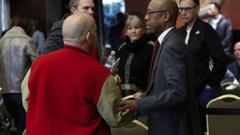 Ohio State president Michael Drake shakes hands with Michael DiSabato following his testimony about Dr. Richard Strauss during an Ohio State University Board of Trustees meeting at the Longaberger Alumni House on Nov. 16, 2018. ADAM CAIRNS/THE COLUMBUS DISPATCH