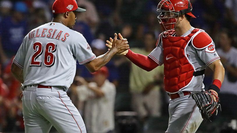 CHICAGO, ILLINOIS - JULY 15: Raisel Iglesias #26 and Kyle Farmer #52 of the Cincinnati Reds celebrate a win against the Chicago Cubs at Wrigley Field on July 15, 2019 in Chicago, Illinois. The Reds defeated the Cubs 6-3. (Photo by Jonathan Daniel/Getty Images)