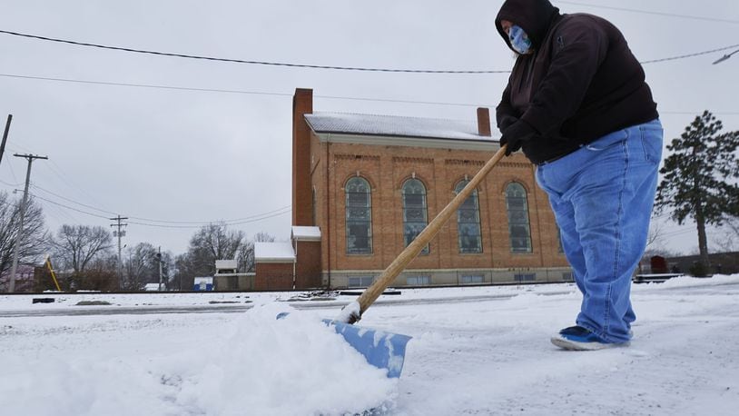 Dan Entsminger Jr. shovels snow outside D&M Tire on Front Street Monday, Jan. 17, 2022 in Hamilton. NICK GRAHAM / STAFF