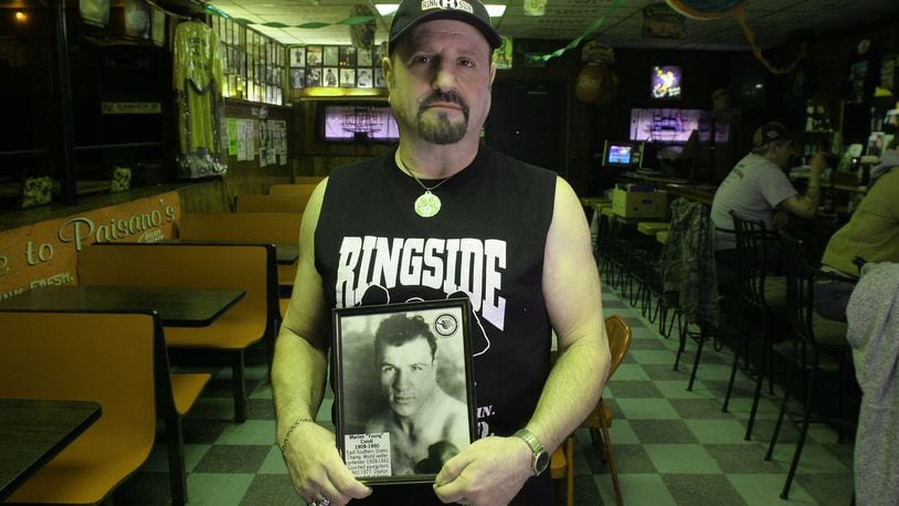 Rick Condi holds a picture of his dad, Marian "Young" Condi, at Paisano Pizza and Pub in Dayton. DDN FILE