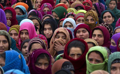 Kashmiri village women watch the funeral procession of Imtiyaz Ahmed, a suspected militant of Lashkar-e-Taiba, in Petipora, a village 55 kilometers (34 miles) south of Srinagar, India.