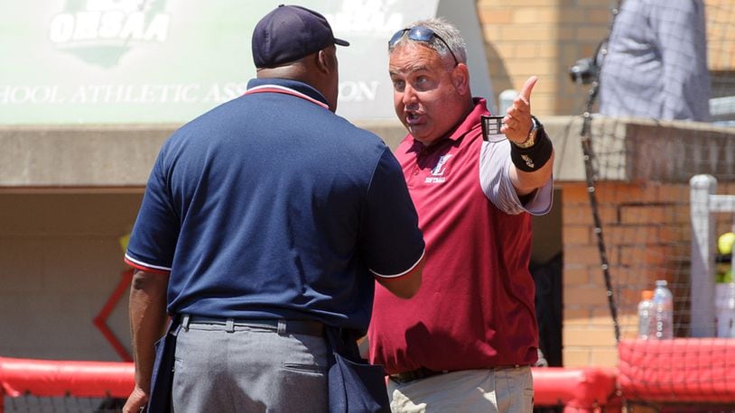 Lebanon coach Brian Kindell (right) argues with home-plate umpire Mike Burwell after Elyria scored the winning run in the bottom of the seventh inning of Saturday’s Division I state final at Firestone Stadium in Akron. CONTRIBUTED PHOTO BY BRYANT BILLING