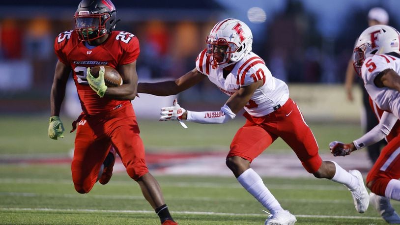 Lakota West running back Cameron Goode tries to elude Fairfield safety Christian Jackson (10) during Friday night's game at West. Nick Graham/STAFF