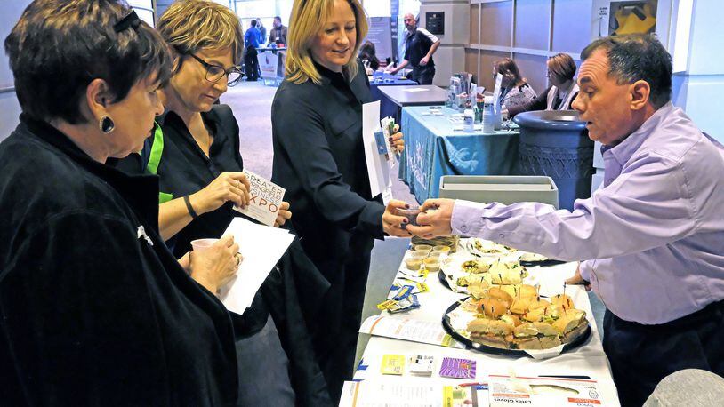 Sue Smedley, left, Lisa Smedley, Center, and Liz Simonton try samples at Tim Poulos’ Tropical Smoothie Cafe booth at the Springfield Business EXPO at the Clark State Performing Arts Center. Bill Lackey/Staff