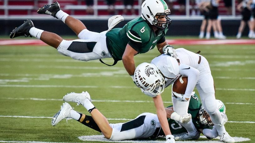 Badin’s Lavassa Martin (6) and Marshall Flaig (5) tackle Roger Bacon’s Zak Cappel during their game Sept 22, 2017, at Fairfield Stadium. The host Rams won 41-21. NICK GRAHAM/STAFF