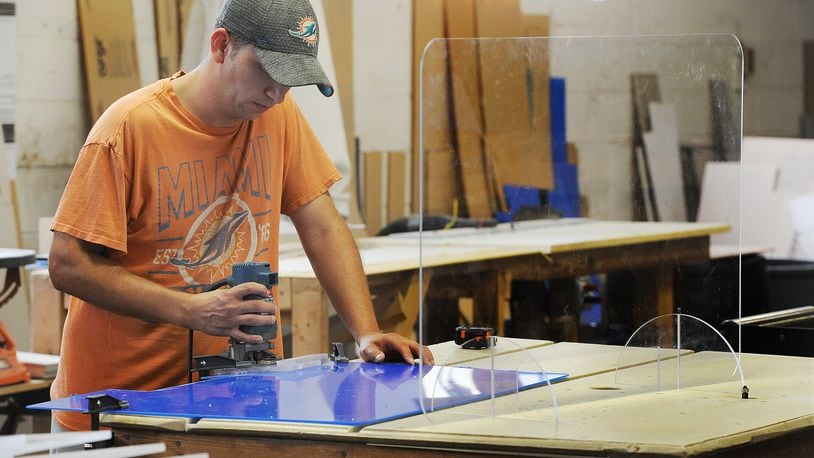 Tim Stewart, an employee of Kohlfab Custom Plastic Fabrication, works on making plexiglass barriers. MARSHALL GORBY\STAFF