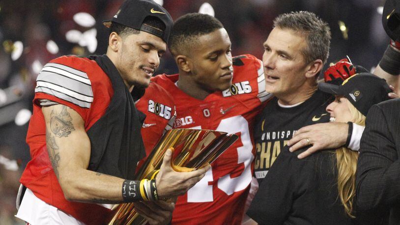 Ohio State’s Devin Smith, left, Darron Lee, Urban Meyer and his wife Shelley, far right, celebrate after a victory against Oregon in the national championship game on Monday, Jan. 12, 2015, at AT&T Stadium in Arlington, Texas. David Jablonski/Staff