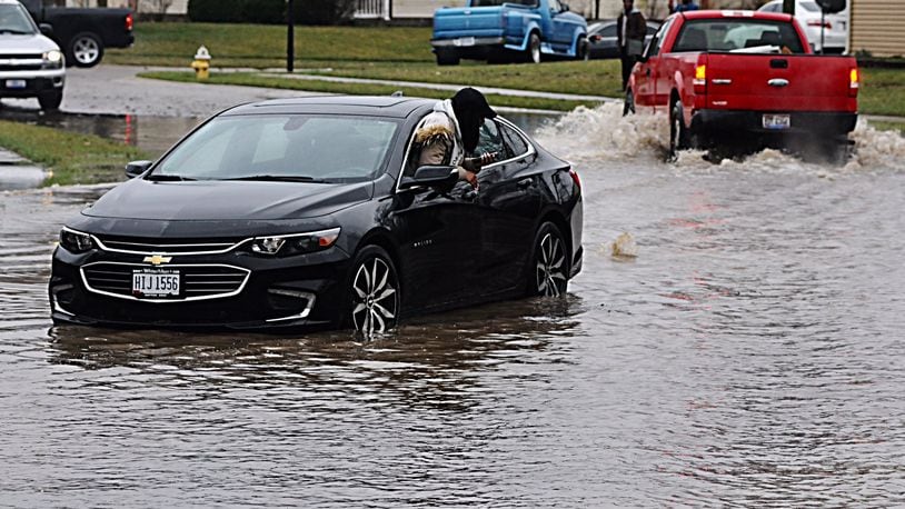 A woman was trapped in high water on Hillary Street in Trotwood as record rain fell on the region Tuesday. MARSHALL GORBY/STAFF
