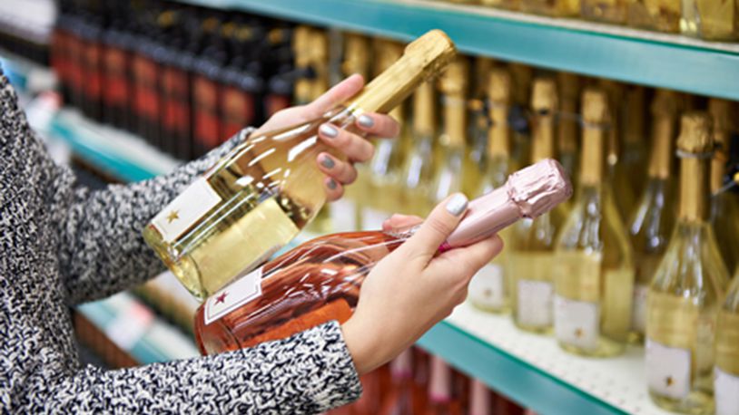 Woman with bottles of rose and white wine in store (Dreasmtime/TNS)