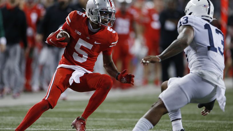 Ohio State receiver Garrett Wilson, left, runs after catching a pass against Penn State linebacker Ellis Brooks during the first half of an NCAA college football game Saturday, Oct. 30, 2021, in Columbus, Ohio. (AP Photo/Jay LaPrete)