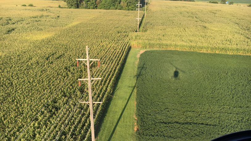 Dayton Power & Light inspectors examine sections of the utility’s 11,000 miles of power lines from a helicopter four times a year. The shadow of a DP&L helicopter can be seen in this photo, as inspectors check out lines in the Brookville area in August 2016. THOMAS GNAU/STAFF