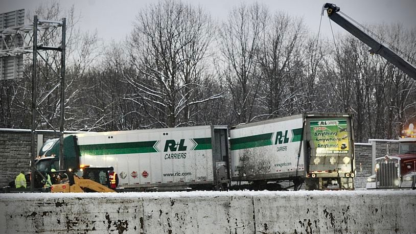 Crews work to remove a semi with two trailers that struck a fence on the exit ramp from I 75 south to 70 early Wednesday morning, January 25, 2023 MARSHALL GORBY\STAFF