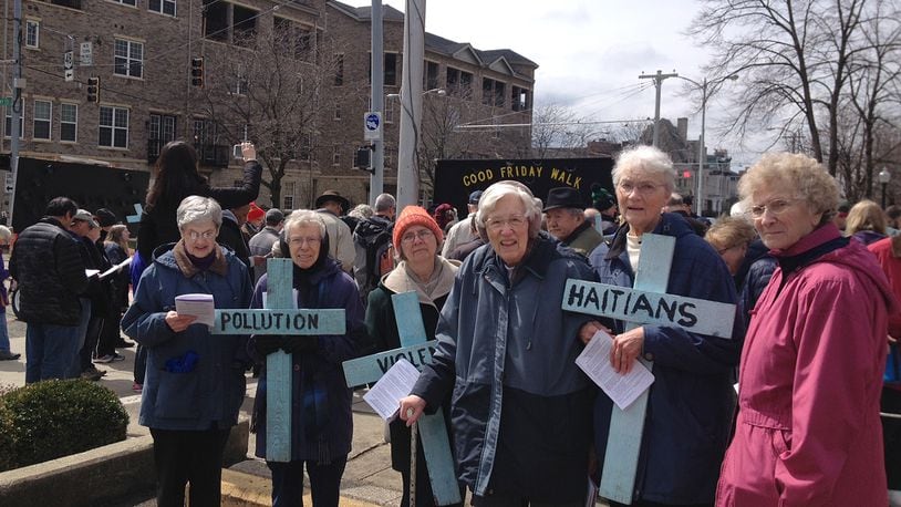 Sisters of the Precious Blood of Dayton carry crosses during a Good Friday walk that show what they've been praying about: support for Haitian immigrants and an end to violence and pollution. Photo provided.