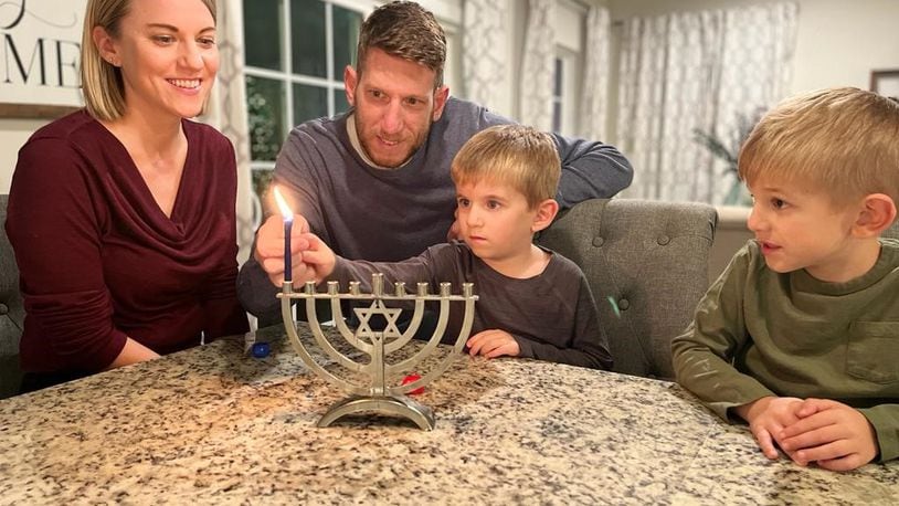The Solovey family, Katie, Tal, Liam and Ben, lights the first candle in the Hanukkah menorah. The Festival of Lights started Sunday. SUBMITTED