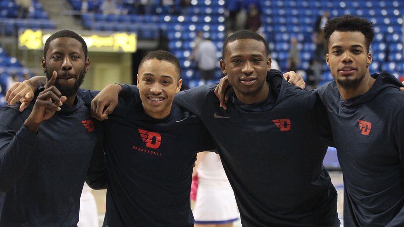 Dayton’s Scoochie Smith, Kyle Davis, Kendall Pollard and Charles Cooke pose for a photo after beating Saint Louis for their 98th career victory  on Feb. 14, 2017, at Chaifetz Arena in St. Louis.