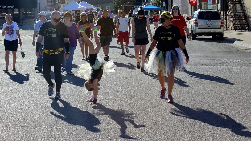 Batgirl Katelyn Patterson does a cartwheel during the one-mile walk while her parents, Charles and Beth Patterson, watch at last year's the Day in Wellville event. MICHAEL COOPER/STAFF