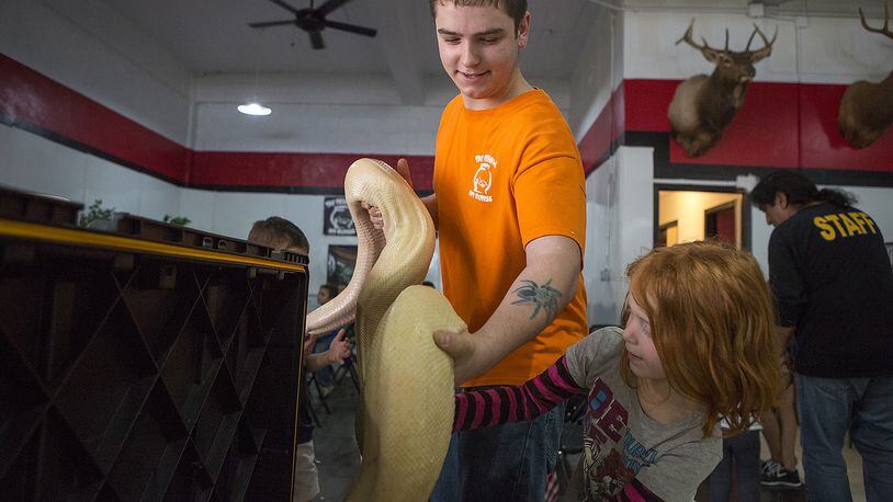 In this March 16, 2015 photo, Grant Thompson handles a large snake during a youth group's visit to Fish Bowl Pet Express in Temple, where Thompson was a senior staff member. Thompson, 18, died Tuesday, July 14, 2015, from an apparent snakebite after emergency medics found him in his car in North Austin.