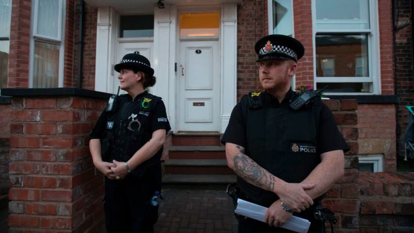 Police officers stand on duty outside a residential property in Manchester on Thursday.