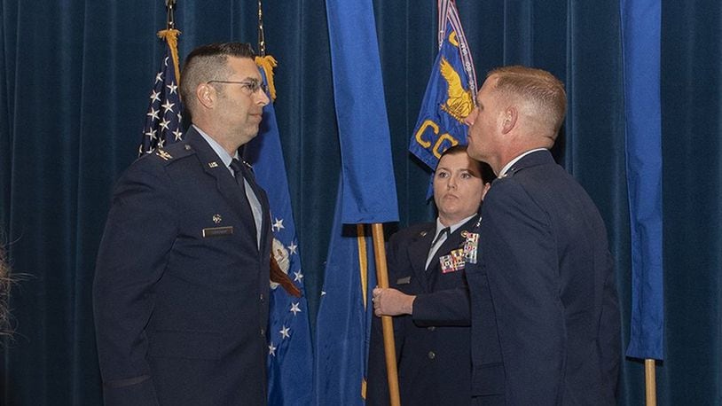 Col. Thomas Sherman (left), 88th Air Base Wing and installation commander, and Lt. Col. Josef R. Wein, 88th Operations Support Squadron commander, perform a realignment ceremony inside the 88th Medical Group auditorium at Wright-Patterson Air Force Base Feb. 27. The ceremony marks the realignment of the 88 OSS under the 88th Communications Group. (U.S. Air Force photo/Michelle Gigante)