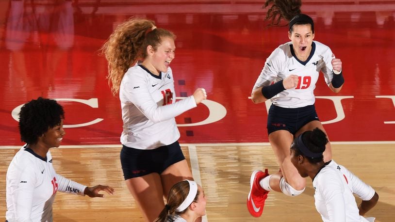 Dayton volleyball players celebrate a point in a match against IUPUI on Sept. 12, 2017, at the Frericks Center. Photo by Erik Schelkun
