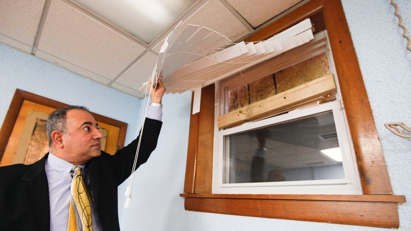 Ayman Salem, vice chairman of the Islamic Society of Greater Dayton, displays a window damaged by a vandalism incident at the Al-Rahman Mosque. CHRIS STEWART / STAFF