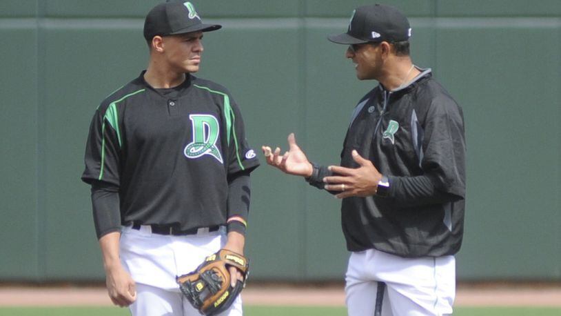 Dragons infielder Luis Gonzalez (left) huddles with manager Luis Bolivar during Wednesday’s practice at Fifth Third Field. MARC PENDLETON / STAFF