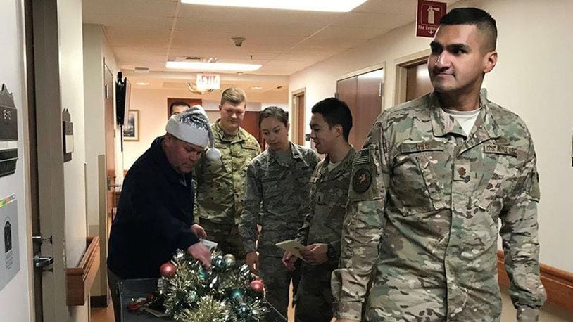 Airmen from the KC-46 office carry wreaths and holiday greetings to residents at the Dayton Veterans Affairs Kennedy Way Community Living Center Dec. 6. The office has visited the VA at Christmastime every year since being awarded the KC-46 contract. Volunteers delivered 80 wreaths this year.