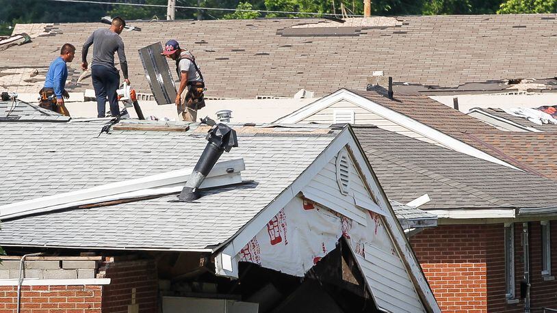 Workers repair the roof of a house in Harrison Twp. next to the Union Chapel Community Church that was destroyed by a Memorial Day tornado. CHRIS STEWART / STAFF