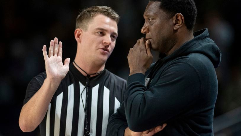 Howard head coach Kenny Blakeney, right, confers with a referee during the first half of an NCAA college basketball game against James Madison in Harrisonburg, Va., Sunday, Nov. 12, 2023. (Daniel Lin/Daily News-Record via AP)