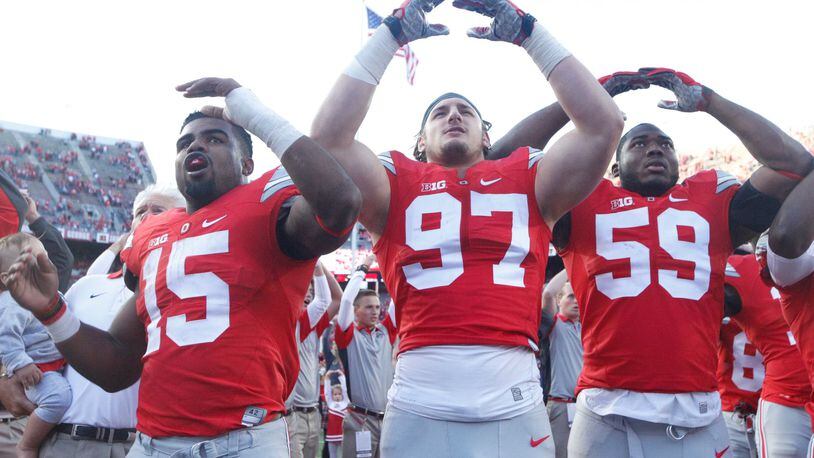 Ohio State’s Ezekiel Elliott, left, Joey Bosa, center, and Tyquan Lewis sing the fight song after a victory against Hawaii on Saturday, Sept. 12, 2015, at Ohio Stadium in Columbus. David Jablonski/Staff