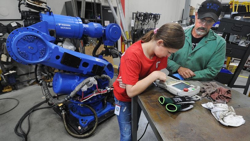 Yaskawa Motoman employee Mic Johnson, right, works with Upper Valley CTC student Madison Copeland at the Miamisburg facility Thursday, June 1, 2023. MARSHALL GORBY\STAFF