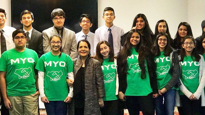 Muslim Youth Outreach (MYO) members shared their experiences with refugees and charity work on Dec. 1 at the Dayton Mercy Society in Miamisburg. Junior MYO members are pictured in the front row (green shirts), and MYO members are in the back row. Founder and coordinator Kaukab Husain is in the center of the front row. CONTRIBUTED