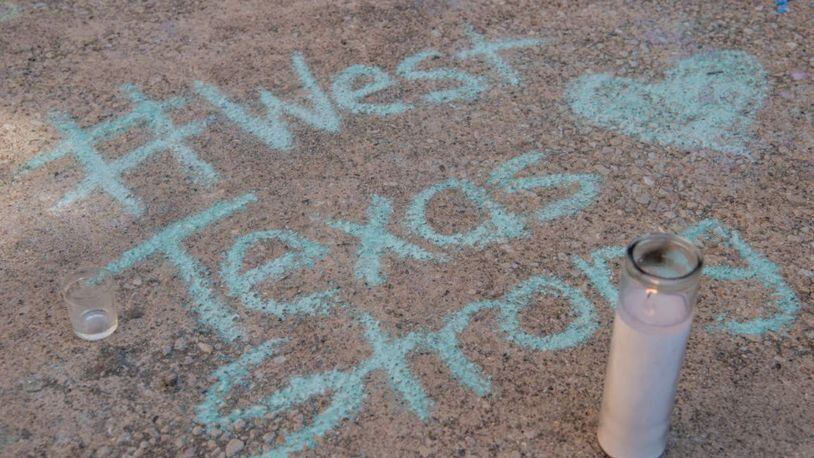 A chalk message at a memorial for victims of a mass shooting in Odessa and Midland, Texas, was created at the University of Texas of the Permian Basin.