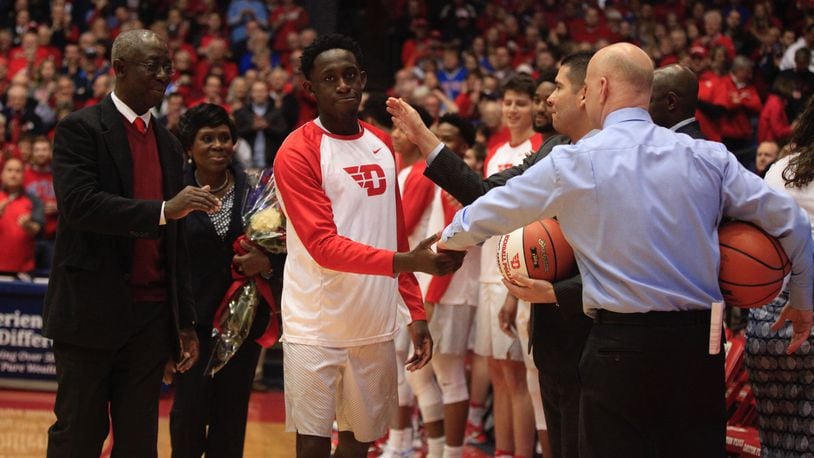 Dayton's Jeremiah Bonsu is honored on Senior Night with his parents on March 1, 2017, at UD Arena.