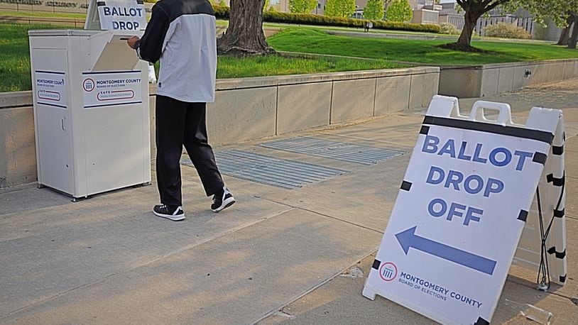 A voter uses the drop box at the Montgomery County Board of Elections on Third Street in Dayton. MARSHALL GORBY / STAFF