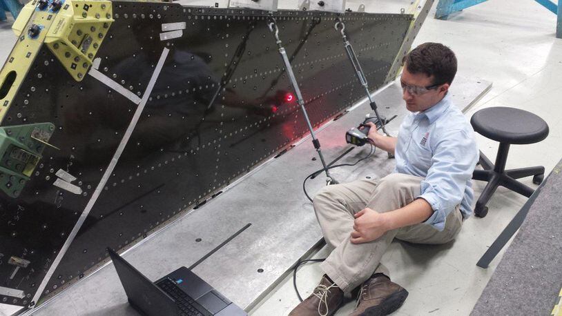 Solomon Duning, research engineer, University of Dayton Research Institute, uses laser scanning technology to inspect an F-16 vertical tail on a depot fixture. (U.S. Air Force photo)