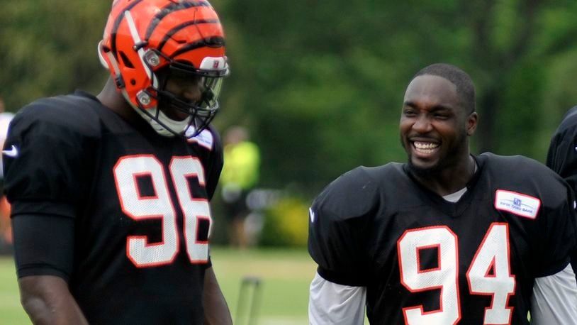 Cincinnati Bengals defensive ends Chris Smith (right) and Carlos Dunlap share a laugh during a break in Thursday’s practice at Paul Brown Stadium. JAY MORRISON/STAFF