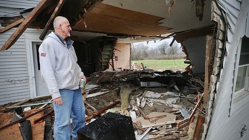 Dave Fisher looks at what is left of his house on Friday, March 31, 2023, after a semi drove through it Thursday evening at state Routes 571 and 201 in Bethel Twp. Fisher’s wife was inside and only suffered minor injuries, but the house will be demolished and rebuilt, Fisher says. MARSHALL GORBY \STAFF