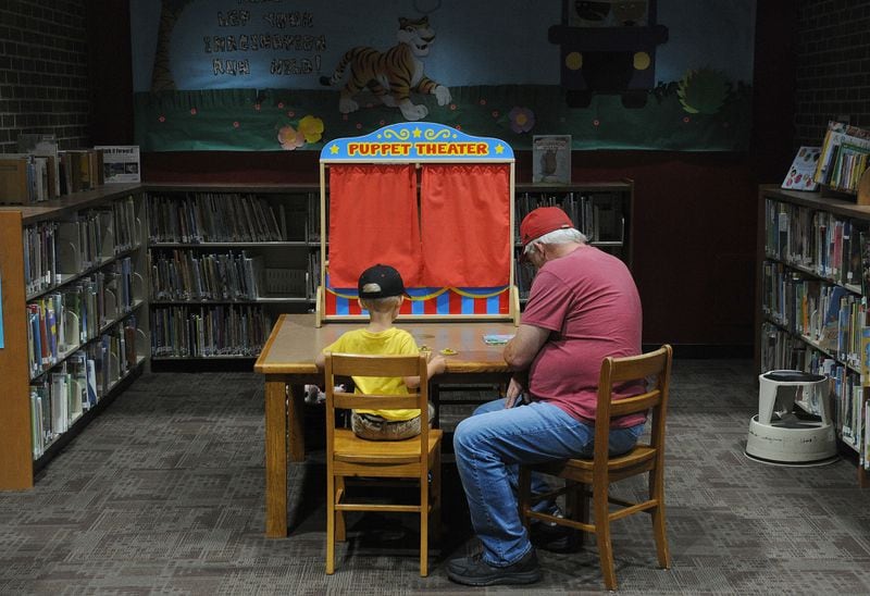 Bill Call and his grandson Zayne, 3, work on a puzzle together at the Troy-Miami County Public Library Thursday July 1, 2021. MARSHALL GORBYSTAFF